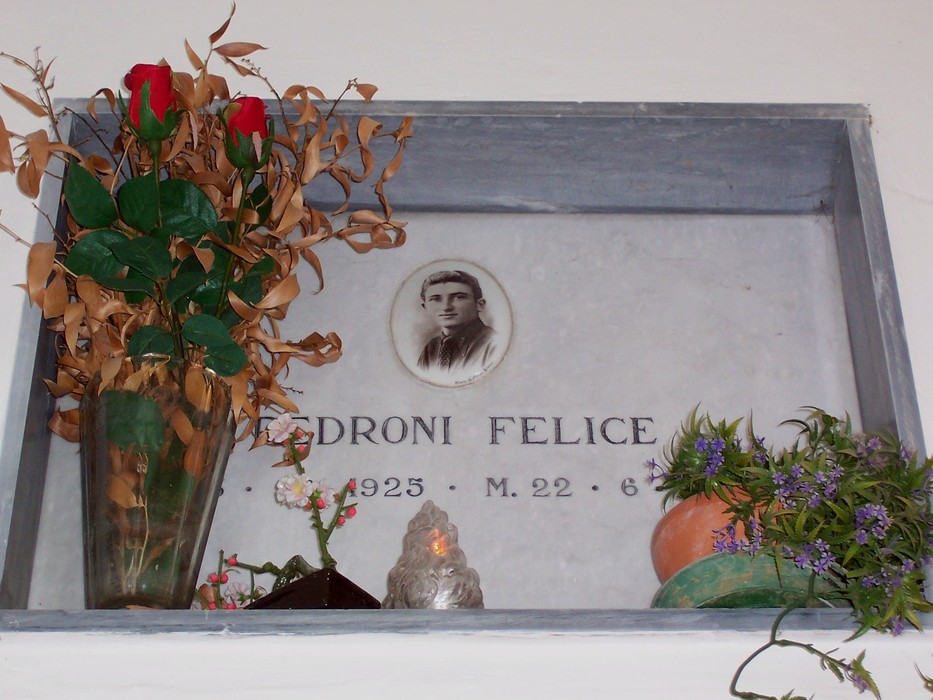 Riproduzione della Cappella dei Caduti Partigiani, con fiori e omaggio a un caduto.