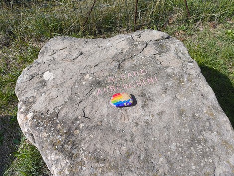 Monumento in memoria dei partigiani caduti, situato a Monte Sabbiuno, con un'omaggio decorativo.