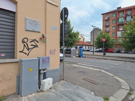 Lapide commemorativa dedicata ad Ansaldi, situata su un edificio all'angolo di una strada urbana.
