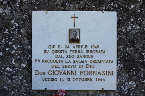 Lapide commemorativa dedicata a Don Giovanni Fornasini, ucciso nel 1944, situata in un luogo significativo.