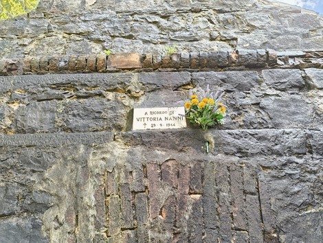 Rovine della chiesa di Casaglia, con fiori e un dedicato in memoria di Vittoria Nannini.
