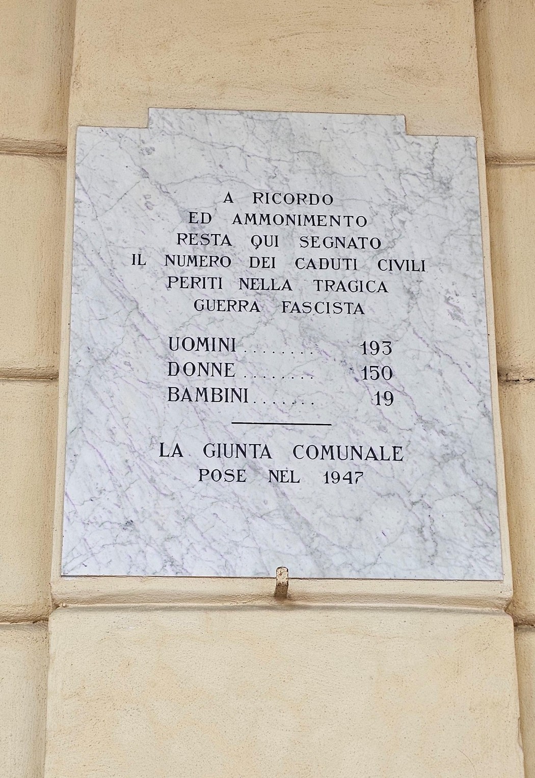 Lapide commemorativa dedicata ai caduti civili, con dettagli su uomini, donne e bambini periti nella guerra fascista.