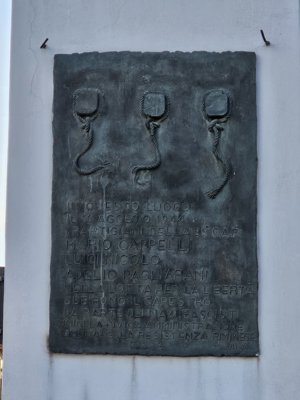 Targa commemorativa ai Tre Martiri, dedicata ai partigiani caduti nella resistenza. Design sobrio e significativo.