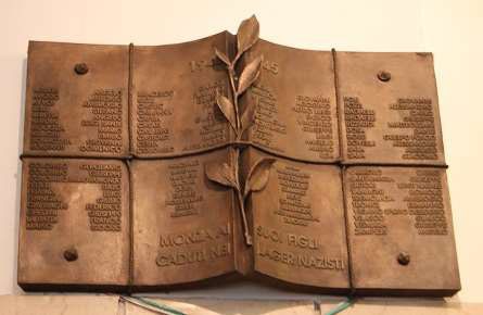 Targa commemorativa dedicata ai deportati, con nomi e simboli di memoria e resistenza.
