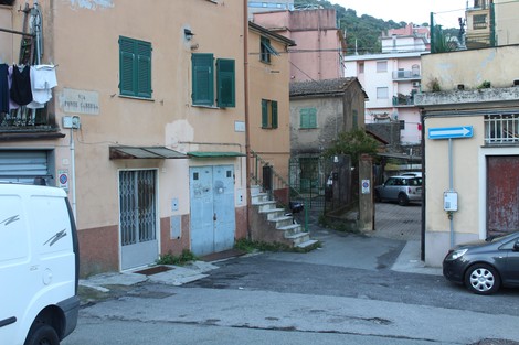 Targa stradale in un contesto urbano, con edifici residenziali e una strada che si biforca.