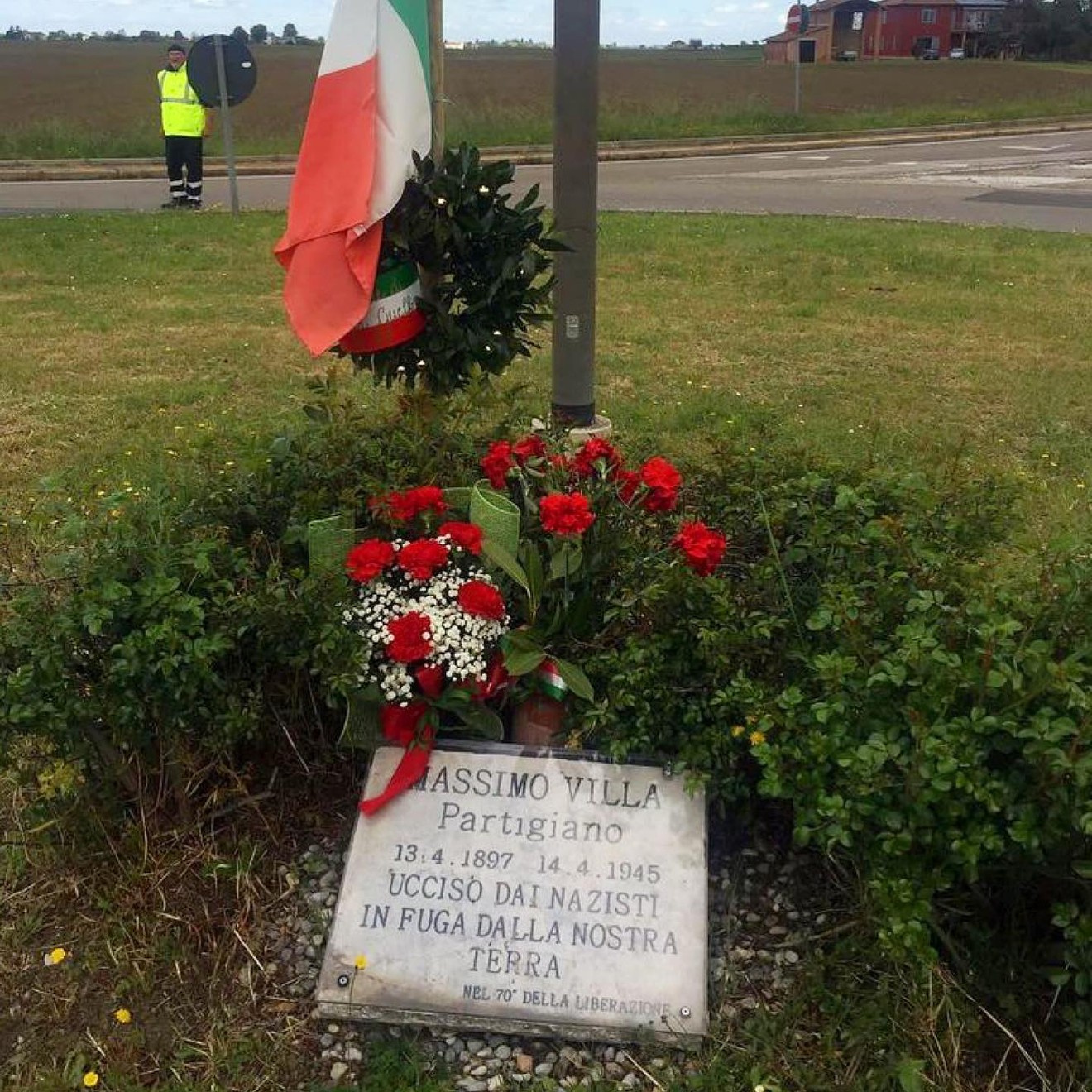 Lapide commemorativa a Massimo Villa, partigiano ucciso dai nazisti il 14 aprile 1945, con fiori e omaggio.
