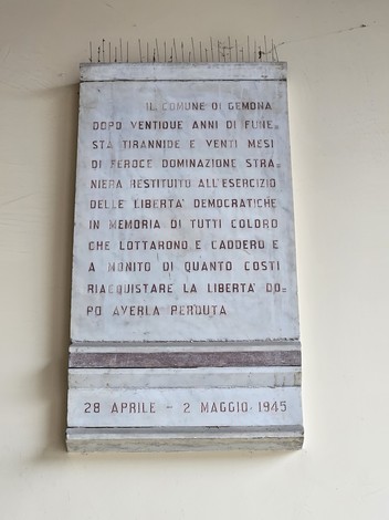 Lapide commemorativa che ricorda la Resistenza, con iscrizioni sulla libertà e i sacrifici fatti.