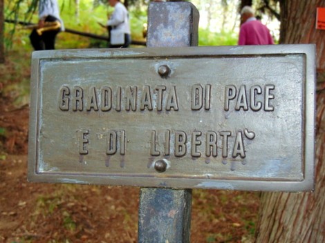 Targa commemorativa dedicata ai partigiani, simbolo di pace e libertà in un contesto storico significativo.