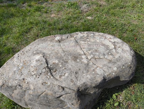 Monumento ai partigiani caduti a Monte Sabbiuno, pietra commemorativa immersa nel verde.