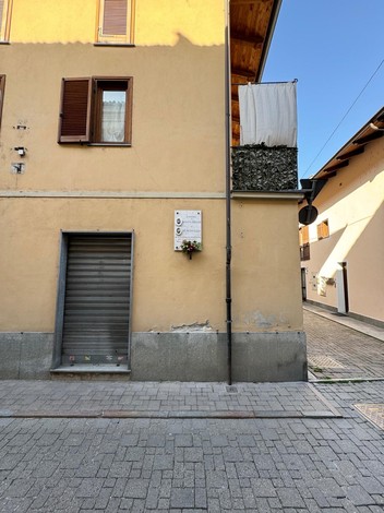 Lapide commemorativa su un edificio, dedicata a Baratta e De Pietri, in un contesto urbano.