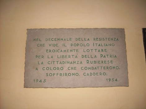 Lapide commemorativa che celebra il decennale della Resistenza italiana, onorando i combattenti e la libertà.