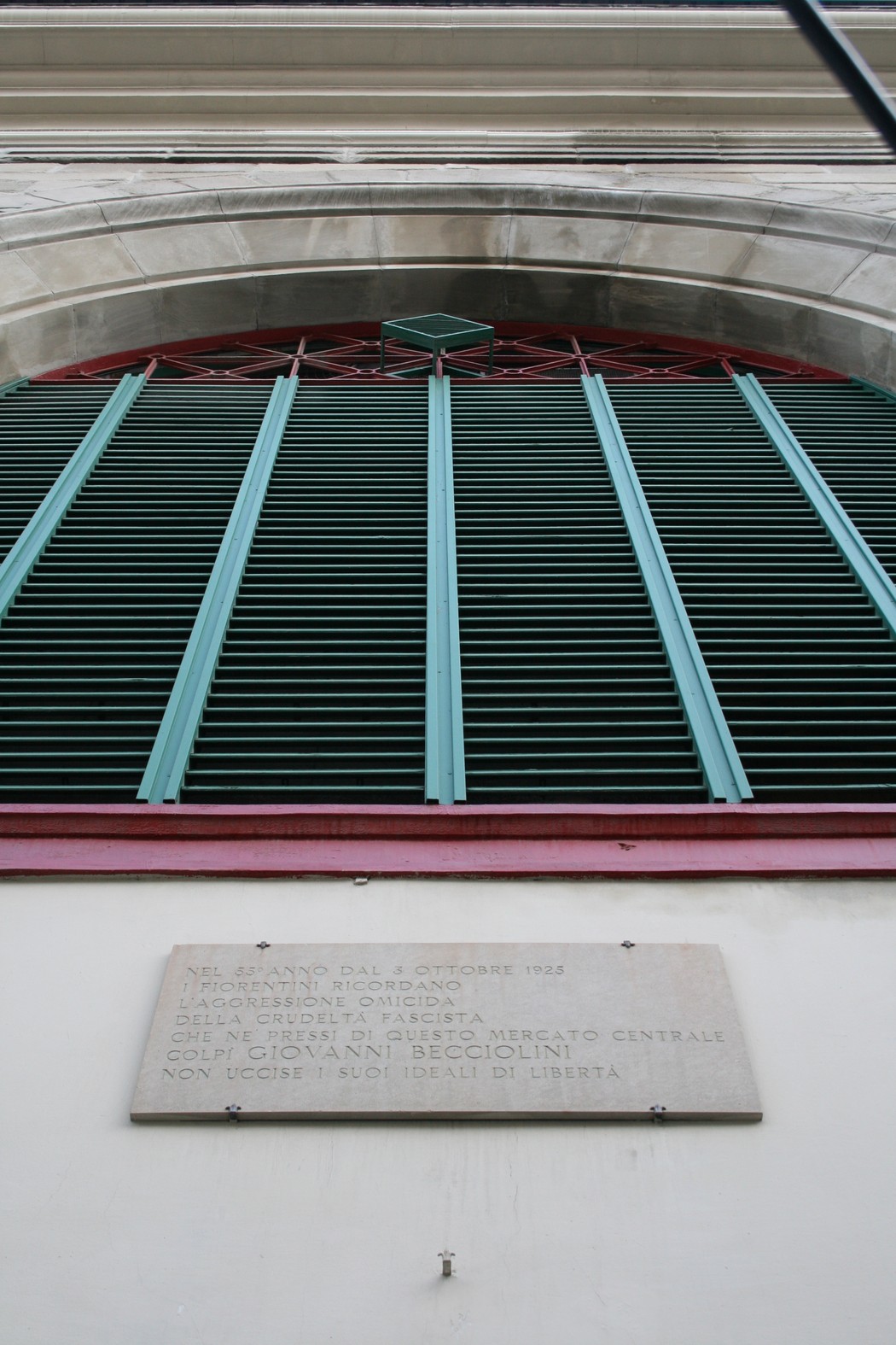 Lapide commemorativa dedicata a Becciolini, situata nel mercato centrale, simbolo di libertà e memoria storica.