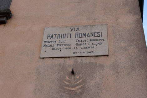Lapide commemorativa dedicata ai patrioti romanesi, con nomi e data di ricordo.