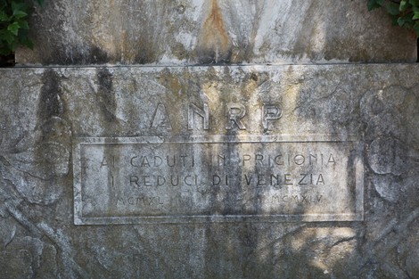 Monumento dedicato ai militari caduti in prigionia, con iscrizioni commemorative e decorazioni floreali.