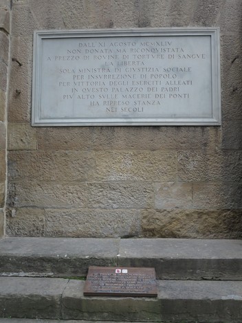 Lapide commemorativa della riconquista di Palazzo Vecchio, simbolo di libertà e giustizia sociale.