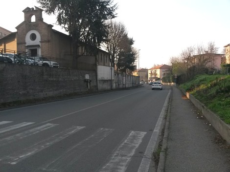 Immagine della strada che conduce alla "Lapide ad Amati e Fondrini", con edifici storici sullo sfondo.