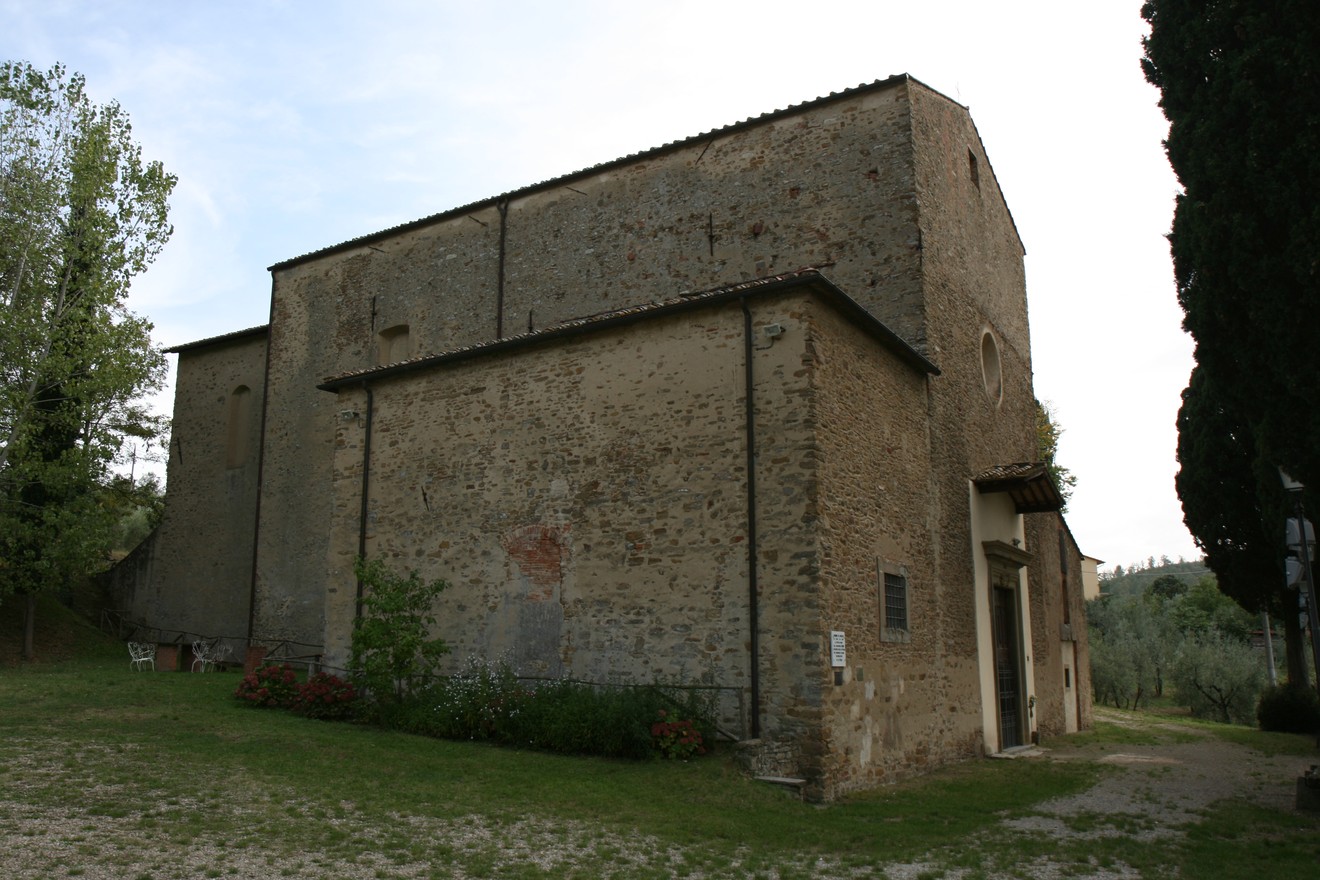 Lapide commemorativa per l'eccidio di San Polo, situata vicino a un antico edificio in un contesto rurale.