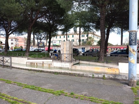Monumento ai caduti per la libertà di Centocelle, circondato da alberi e strade città.