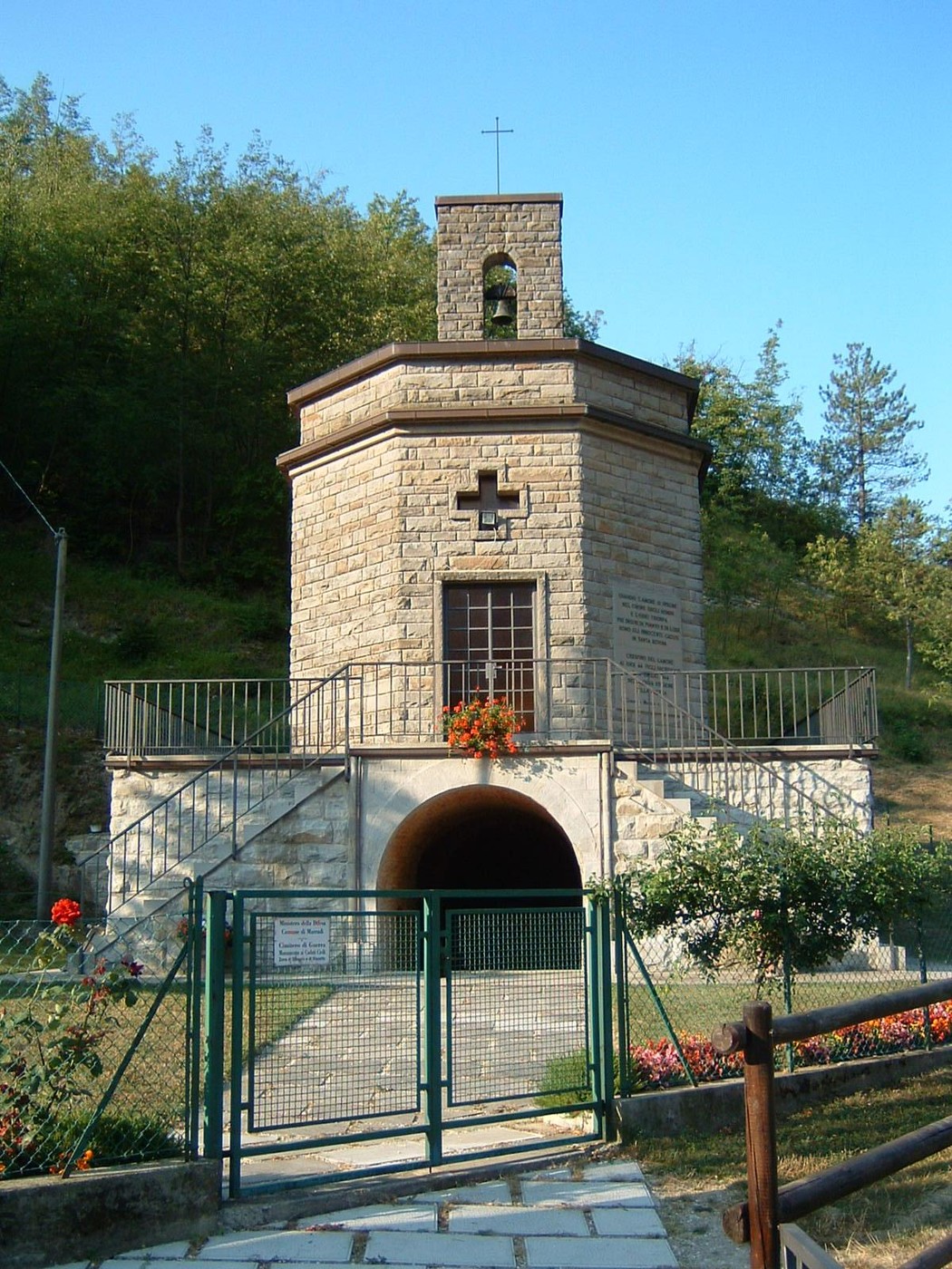 Ossario di Crespino del Lamone, monumento commemorativo immerso nella natura, con struttura in pietra e croce.