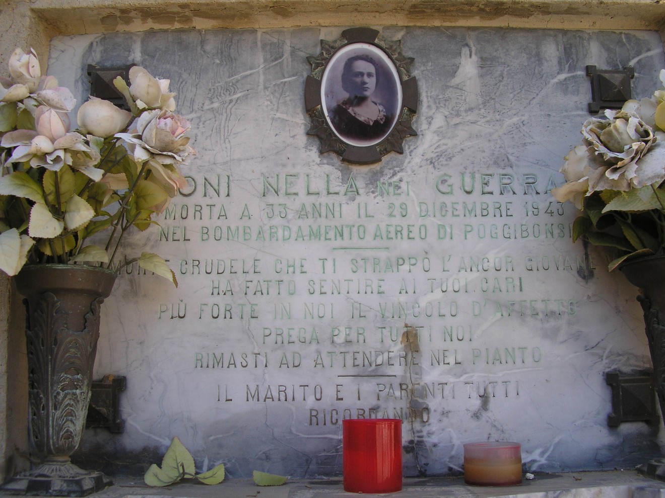 Tomba commemorativa di Batoni, con fiori, candele e foto, in ricordo della vittima del bombardamento del 1943.