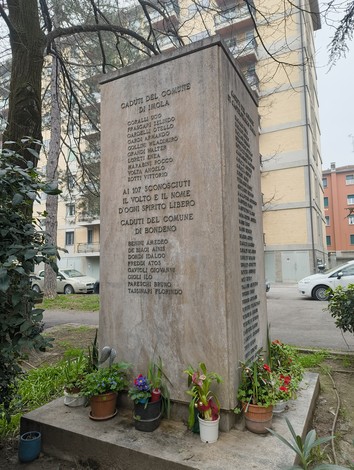 Monumento ai partigiani uccisi a San Ruffillo, commemorazione con nomi e fiori in un contesto urbano.