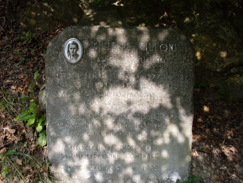 Cippo commemorativo dedicato a Giuseppino Cilloni, situato in un ambiente naturale.