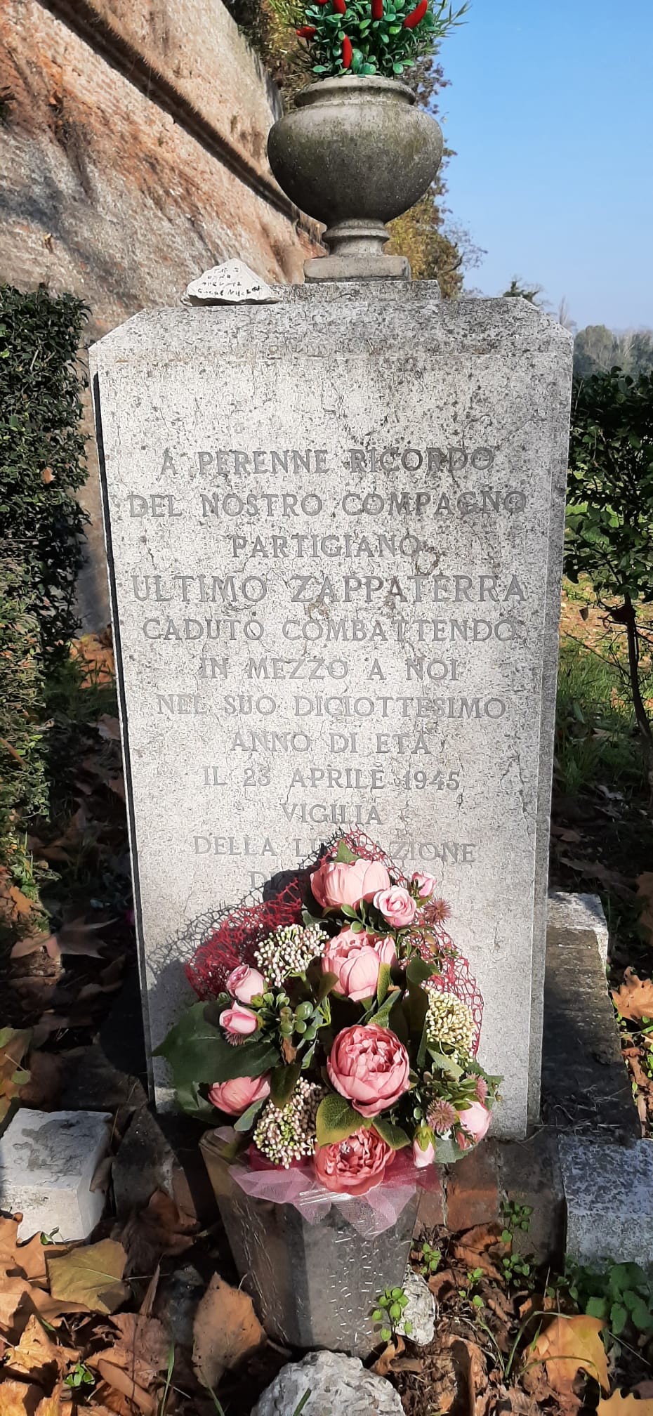 Cippo commemorativo a Zappaterra, con decorazioni floreali e iscrizioni in memoria di un partecipante alla guerra.