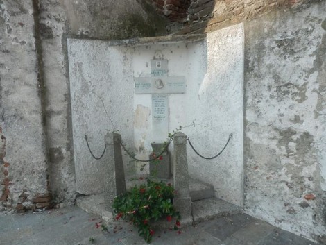 Croce a Marchese, monumento storico con decorazioni floreali, situato in un'area rustica e suggestiva.