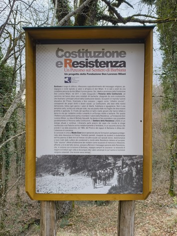 Pannello informativo del "Sentiero della Resistenza" immerso nella natura, con testo su Costituzione e Resistenza.
