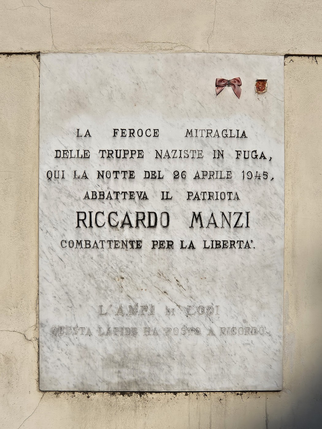 Lapide commemorativa in onore di Riccardo Manzi, patriota ucciso durante la resistenza contro i nazisti.