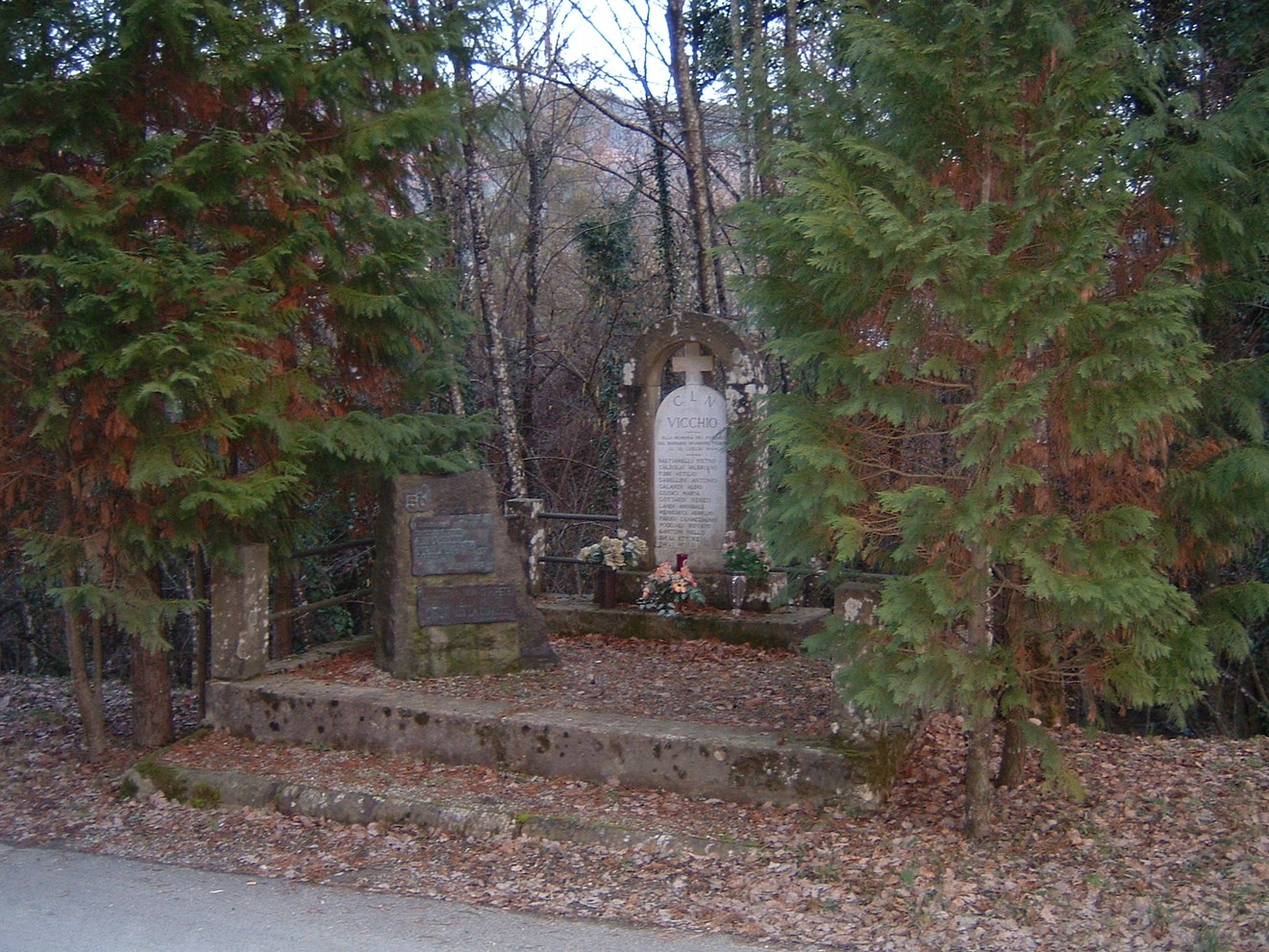 Monumento di Padulivo immerso nella natura, circondato da alberi e foglie, in memoria di eventi storici.
