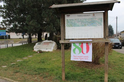 Il Monumento a Caslini è visibile con una mappa circostante e un messaggio commemorativo nei pressi della strada.