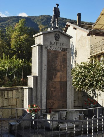 Monumento ai caduti di Mattie, commemorativo, con elenchi di nomi e statue in un ambiente montano.