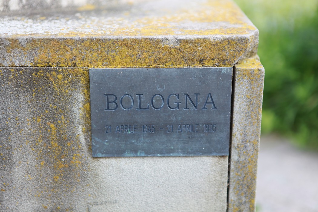 Statua commemorativa per il 50° anniversario della Liberazione a Bologna, con iscrizioni su placca di metallo.