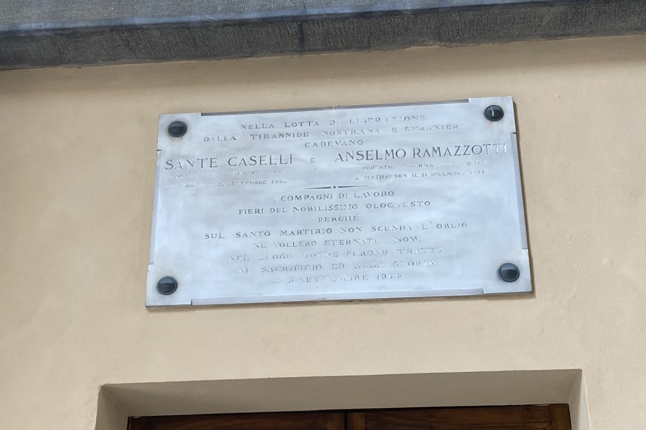 Lapide commemorativa dedicata a Sante Caselli e Anselmo Ramazzotti, situata su una muratura.