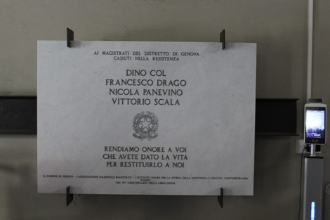 Lapide commemorativa in onore dei magistrati caduti durante la Resistenza, con nomi incisi e simboli patriottici.