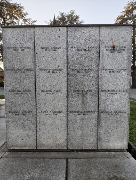 Monumento commemorativo con nomi incisi, dedicato alla memoria di caduti, circondato da un contesto di natura e tranquillità.