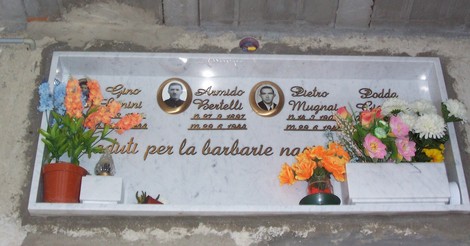 Ossario di Cetica: monumento commemorativo con targhe per i caduti, adornato da fiori e messaggi di ricordo.