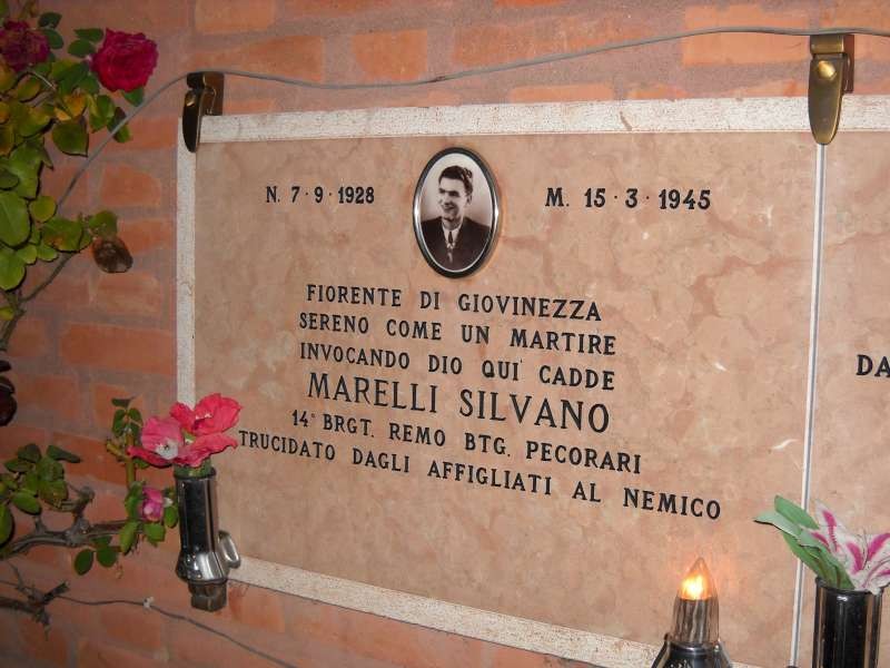 Lapide commemorativa di Silvano Marelli, decorata con fiori, in onore della sua memoria e del suo sacrificio.
