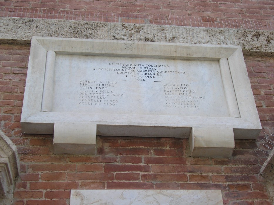 Lapide commemorativa dedicata ai caduti della Resistenza, situata in un contesto storico significativo.