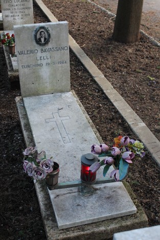 Tombe con fiori e candele, commemorano i caduti per la Libertà in un luogo di memoria e rispetto.