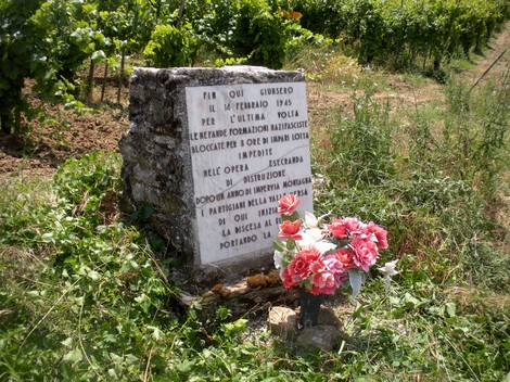 Cippo commemorativo della Battaglia delle Ceneri, in ricordo dei caduti del 1945, con fiori.