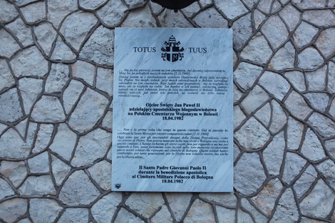 Cimitero di guerra polacco con lapidi e monumenti commemorativi in un ambiente sereno e solenne.
