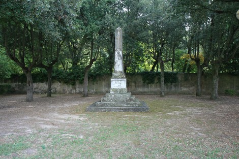 Obelisco ai caduti di Molina, circondato da alberi in un'area verde tranquilla.