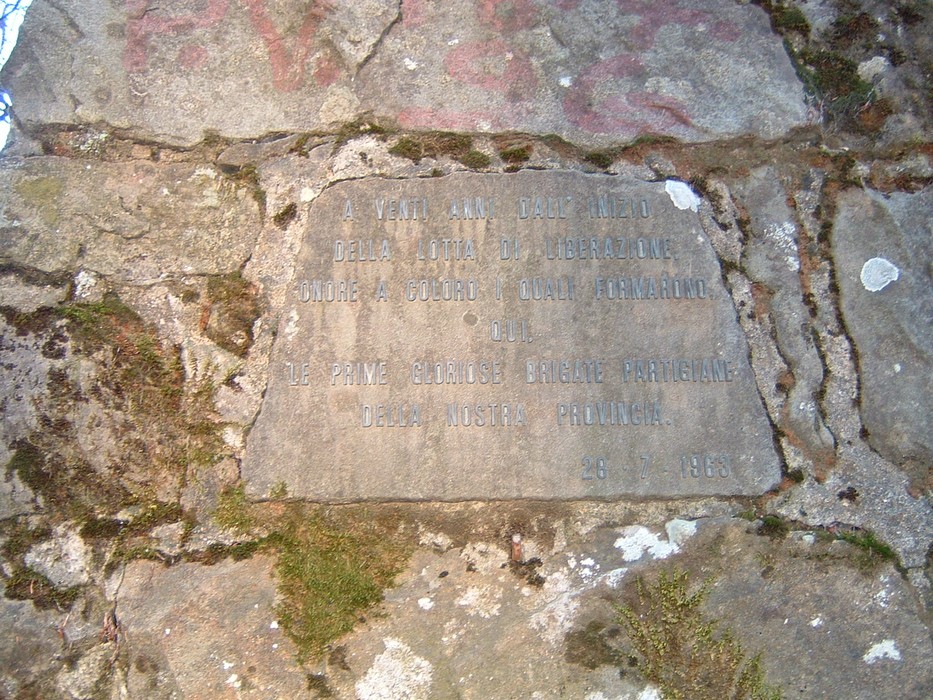 Monumento di Monte Giovi, commemorativo con iscrizioni su una roccia, immerso nella natura toscana.