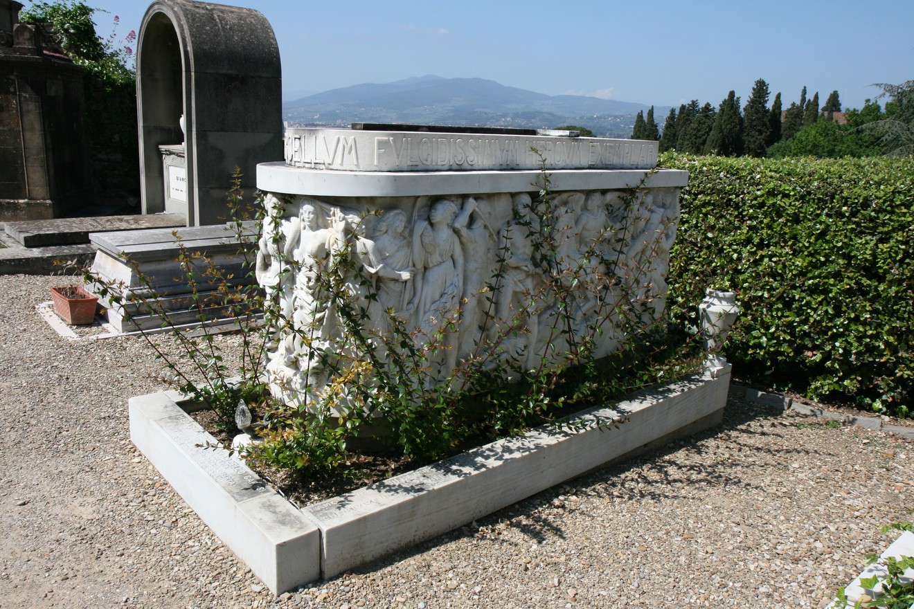Sepolcro di Marcello Garosi, monumento in marmo adornato da figure scultoree e vegetazione circostante.