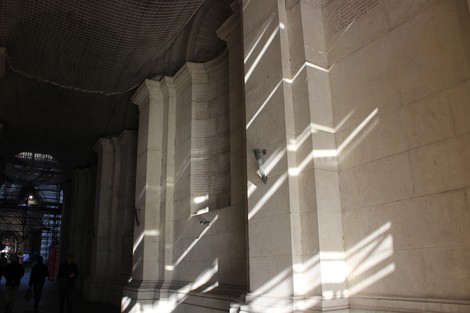 Illuminazione che filtra attraverso le colonne del Sacrario del Ponte Monumentale, creando giochi di luce e ombra.
