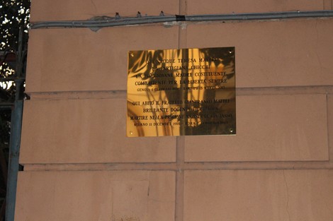 Targa commemorativa dedicata a Enrico Mattei, affissa su un muro. Design semplice con dettagli storici.