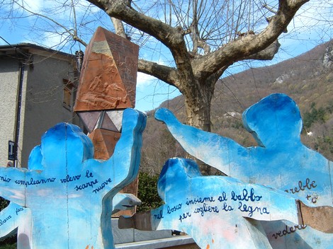 Monumento della piazza di Sant'Anna con sculture e un albero che si staglia sullo sfondo.