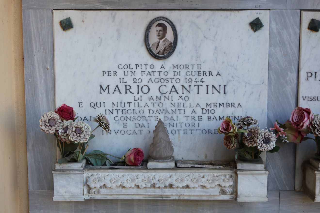 Sepolcro di Mario Cantini, vittima di guerra, decorato con fiori e una scultura, in memoria della sua vita.